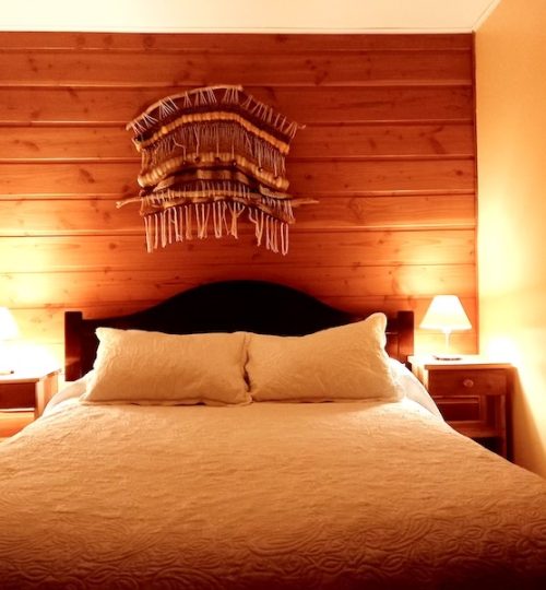 Habitacion de hotel en Pucon con cama matrimonial.
